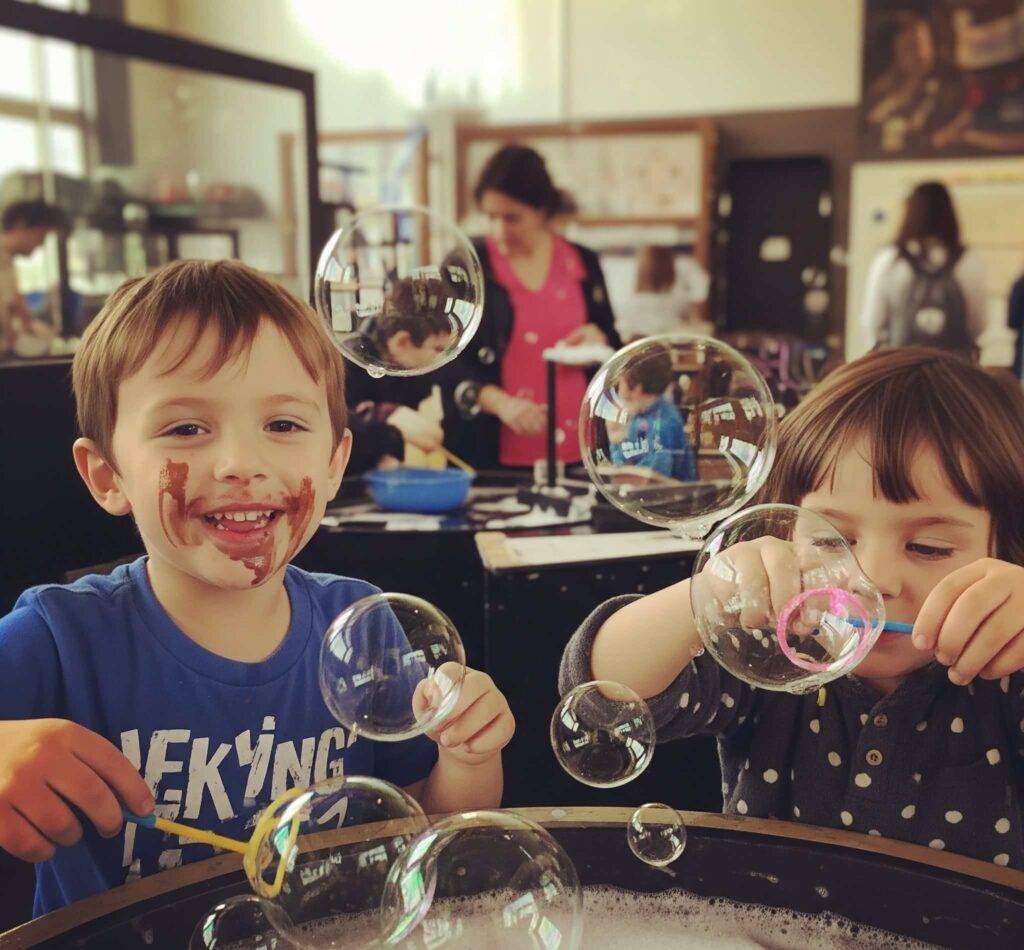 Kids with chocolatey faces, mid-bubble experiment at the Exploratorium