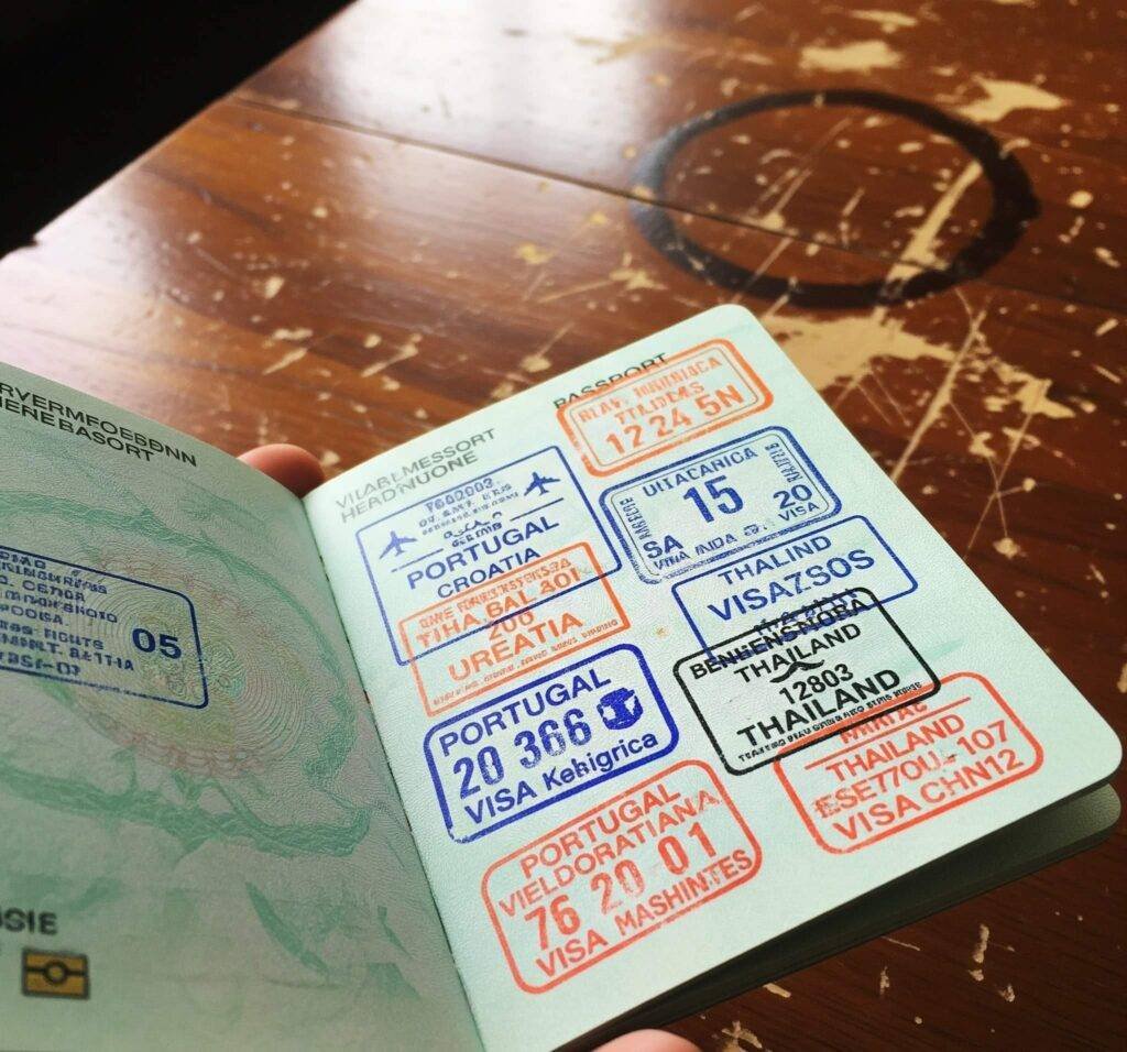 Tilted photo of passport with visa stamps on scratched table